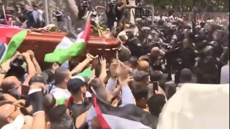 Forças de segurança de Israel impedem que pessoas carreguem o caixão com o corpo da jornalista da al-Jazeera Shireen Abu Akle durante uma procisão funerária para uma igreja, em Jerusalém