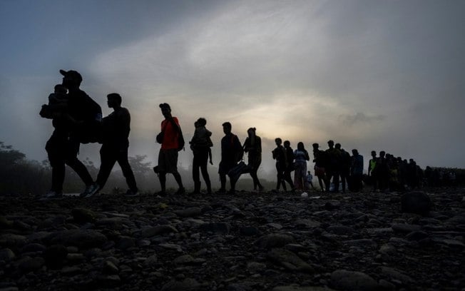 Migrantes caminham pela selva de Darién perto da vila de Bajo Chiquito, no Panamá, em 22 de setembro de 2023