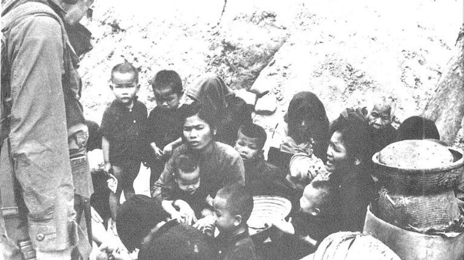 Mães tentam proteger seus filhos dos soldados americanos durante o massacre. 