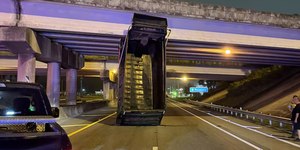 Motorista de caminhão esquece caçamba levantada e bate em viaduto