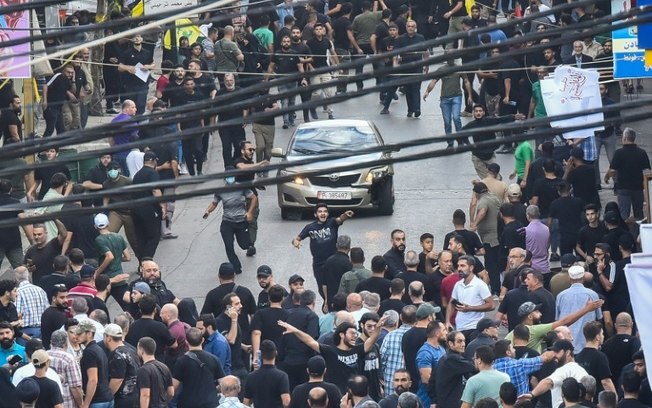 Pessoas correm após explosão durante funeral no sul de Beirute, em 18 de setembro de 2024