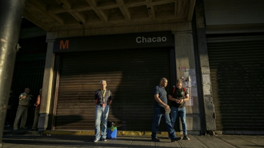 Várias pessoas passam na entrada de uma estação do metrô de Caracas, no dia 30 de agosto de 2024, após o apagão na Venezuela