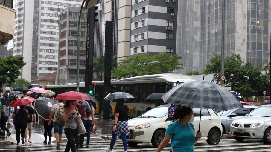 Pedestres se protegem da chuva na Avenida Paulista, em São Paulo