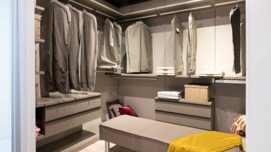 Armário aberto com cortina e capas para roupas também é opção para quem proteger as roupas e acessórios