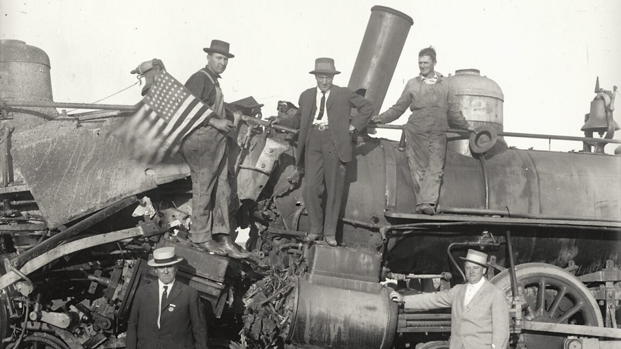 Homens posam com trens retorcidos na Feira Estadual da Califórnia em Sacramento, por volta de 1914–1916. 