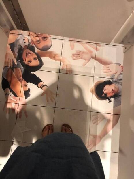 Piso de banheiro decorado com imagens de várias pessoas