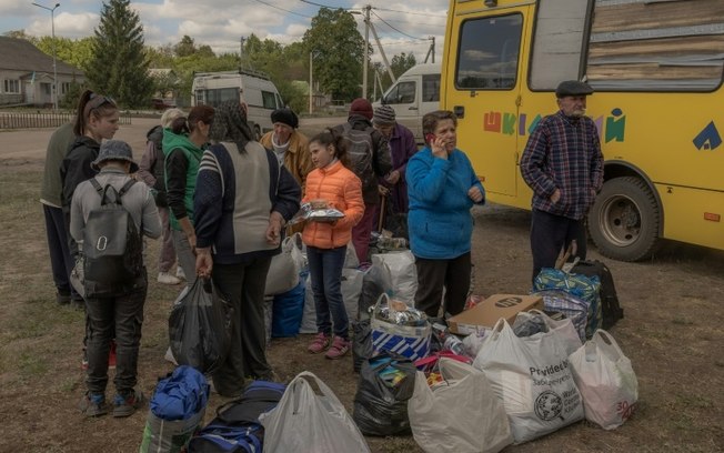 Moradores da cidade de Vovchansk retirados por ataques russos chegam a um ponto de evacuação não revelado em 12 de maio de 2024 na região de Kharkiv, nordeste da Ucrânia