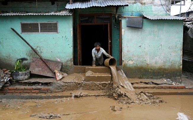 Homem limpa a entrada de sua casa em Katmandu, em 29 de setembro de 2024