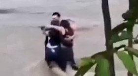 Três amigos se abraçam antes de serem levados por rio