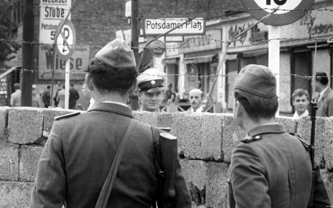 Guardas da Alemanha Oriental observando policiais de Berlim Ocidental em frente ao muro que passou a separar a cidade em 1961 Guardas da Alemanha Oriental observando policiais de Berlim Ocidental em frente ao muro que passou a separar a cidade em 1961