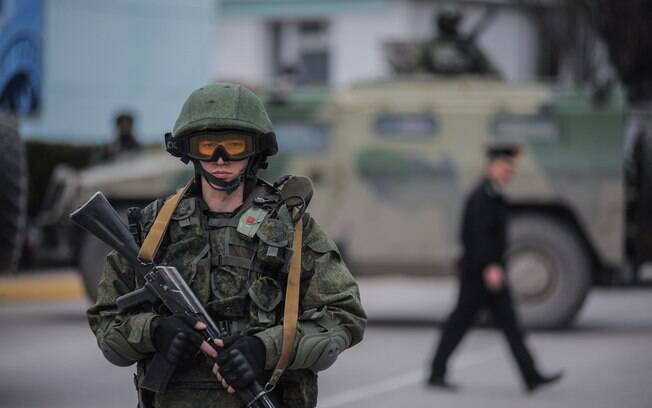 Homem com uniforme sem identificação monta guarda enquanto tropas tomam controle de escritórios da Guarda Costeira em Balaklava, em Sevastopol (Crimeia), na Ucrânia (1/3). Foto: AP