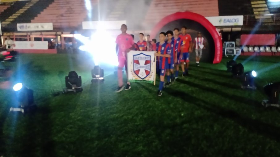 Equipes representando as comunidades entraram perfiladas no campo com túnel inflável, fumaça e show de luzes. Equipes representando as comunidades entraram perfiladas no campo com túnel inflável, fumaça e show de luzes.