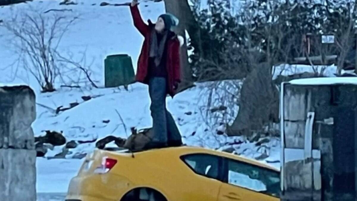 A woman takes a selfie on top of a sinking car in a frozen river |  extraordinary world