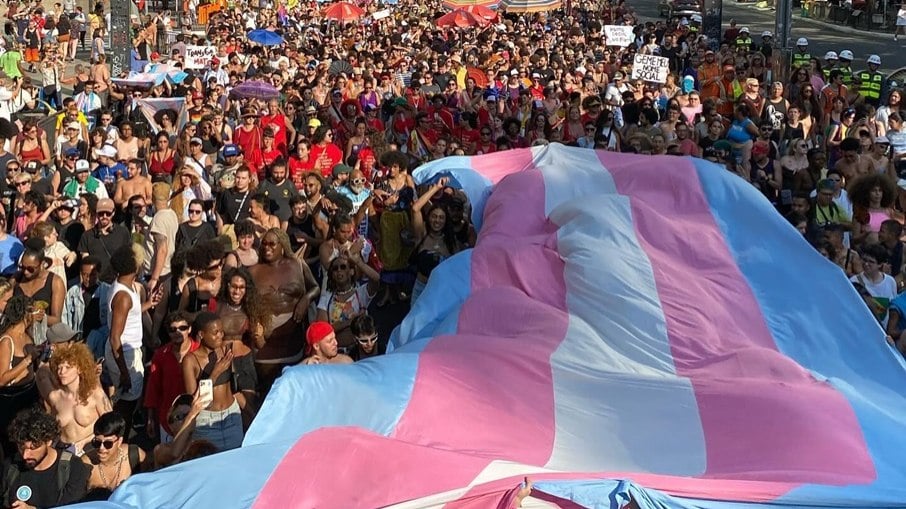 Pessoas estendem bandeira trans na Primeira Marcha Transmasculina, ocorrida em 3 de março de 2024, em São Paulo