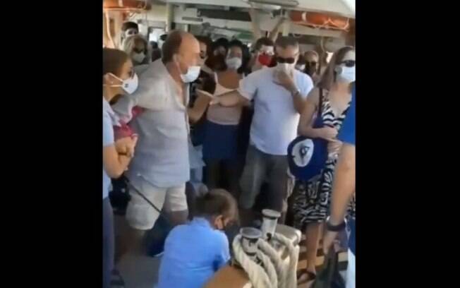 Homem que expulsou jovem que retirou máscara tenta ser controlado por seguranças e outros turistas