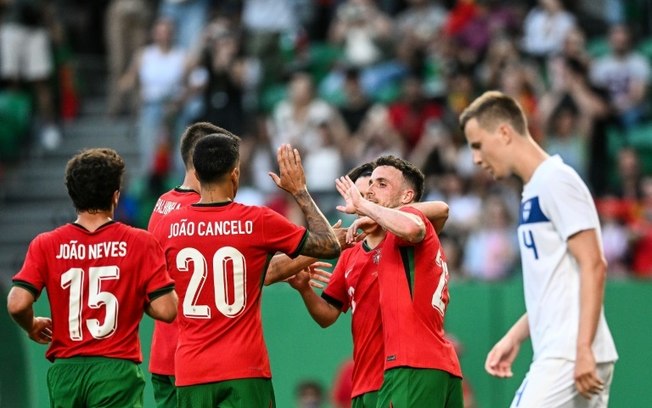 O atacante português Diogo Jota comemora com seus companheiros depois de cobrar um pênalti e marcar durante o amistoso entre Portugal e Finlândia, no estádio Alvalade, em Lisboa, em 4 de junho de 2024