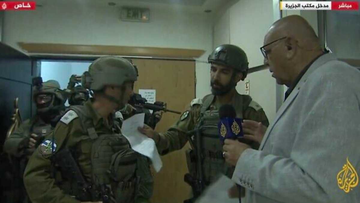 Soldados das IDF entregam a um repórter da Al Jazeera uma ordem militar dirigindo o fechamento de seu escritório em Ramallah