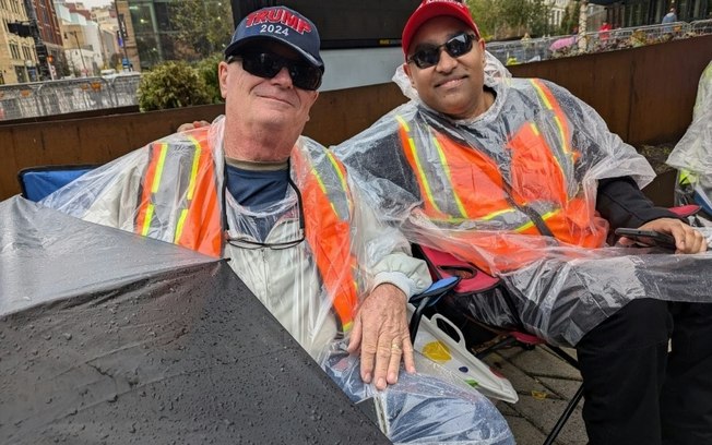 Jeff Dickerson (esq.) e Nigel Mahabir (dir.) esperam na fila para entrar em um comício de campanha do candidato presidencial republicano Donald Trump em Grand Rapids, Michigan