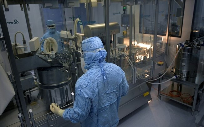 Dois técnicos trabalham no laboratório de embalagens da Sinergium Biotech, no dia 22 de setembro de 2021 na localidade argentina de Garín, na província de Buenos Aires Dois técnicos trabalham no laboratório de embalagens da Sinergium Biotech, no dia 22 de setembro de 2021 na localidade argentina de Garín, na província de Buenos Aires