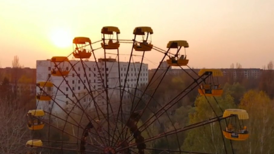 Roda gigante amarela, ao fundo, uma cidade abandonada | Roda gigante amarela, ao fundo, uma cidade abandonada |