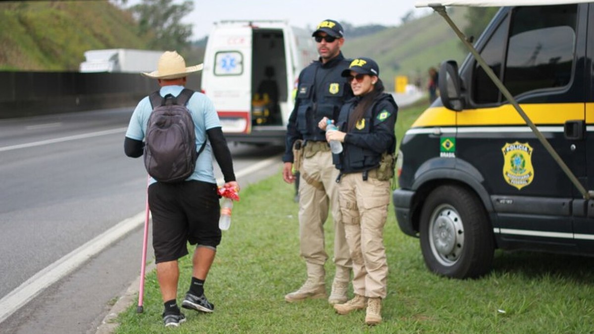 Policiais rodoviários orientam romeiro que caminha pela Dutra Policiais rodoviários orientam romeiro que caminha pela Dutra