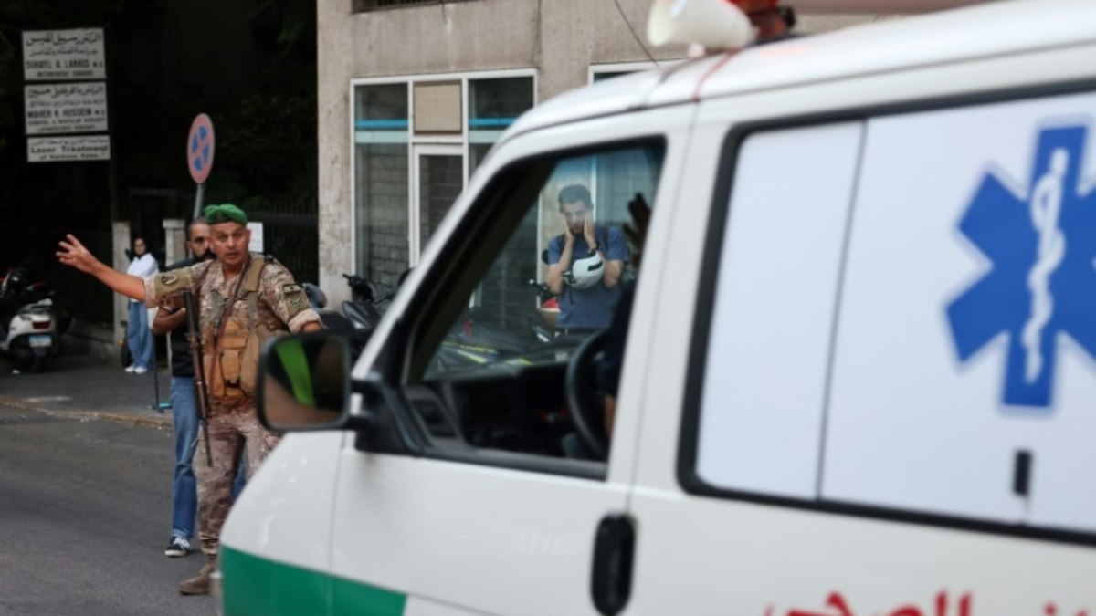 Um soldado do Exército libanês gesticula para uma ambulância que levava pessoas feridas para um hospital em Beirute, em 17 de setembro de 2024, depois que explosões atingiram vários redutos do Hezbollah ao redor do Líbano