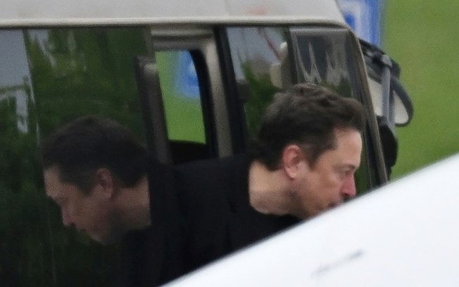 O CEO da Tesla, Elon Musk, deixa um micro-ônibus antes de embarcar em seu avião particular no aeroporto de Pequim