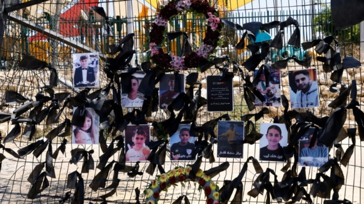 Fotos das crianças e dos jovens mortos no bombardeio de sábado foram penduradas no campo de futebol da aldeia drusa de Majdal Shams, nas Colinas de Golã, anexadas por Israel, em 29 de julho de 2024, em meio aos contínuos confrontos transfronteiriços entre tropas israelenses e combatentes do Hezbollah