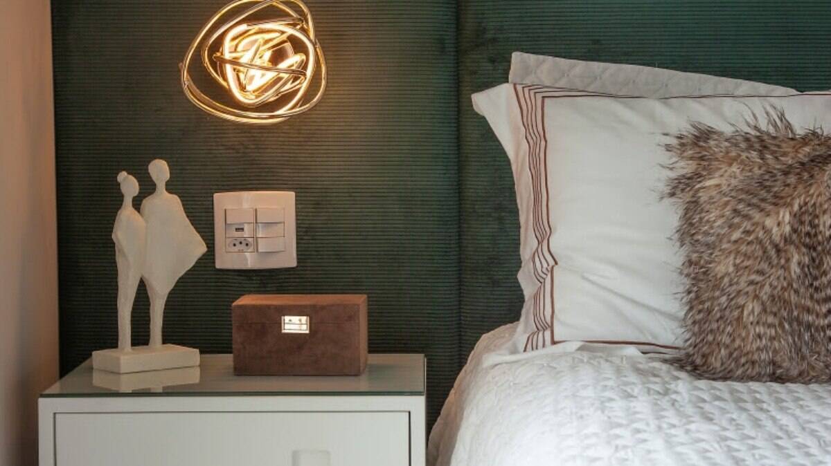 No dormitório do casal, a cabeceira em veludo verde dita a cena do décor