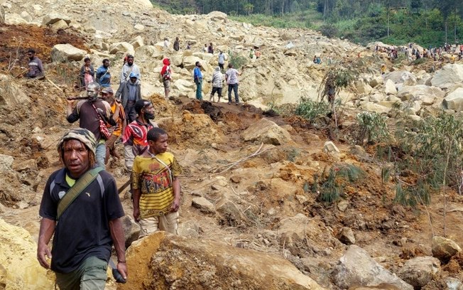 Moradores diante da destruição provocada por deslizamento de terra em Mulitaka, na província de Enga, Papua-Nova Guiné Moradores diante da destruição provocada por deslizamento de terra em Mulitaka, na província de Enga, Papua-Nova Guiné
