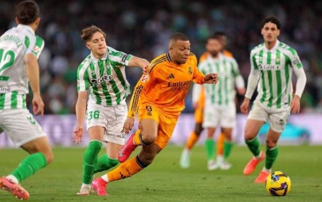 Mbappé em disputa de bola contra jogadores do Betis Mbappé em disputa de bola contra jogadores do Betis