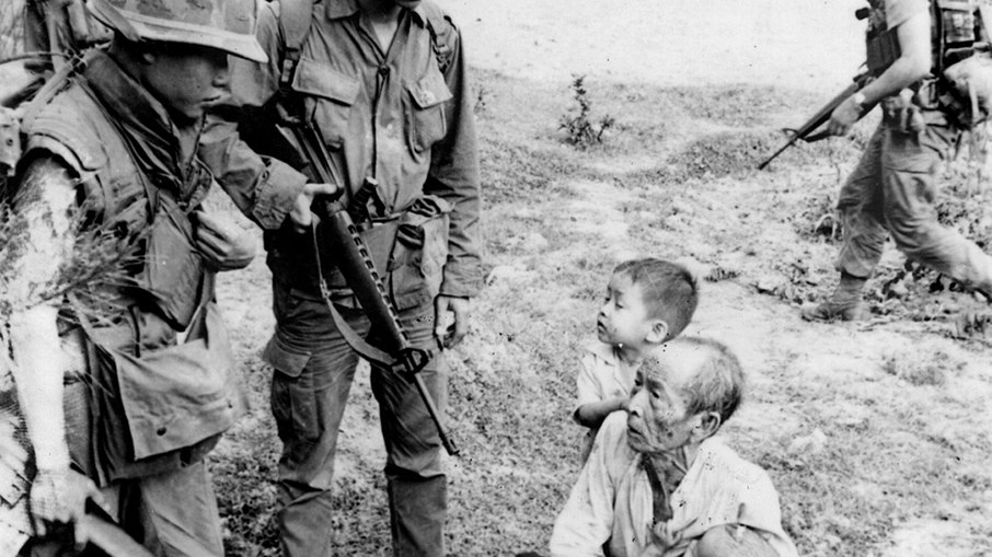 Soldados interrogando cidadãos vietnamitas.  Haeberle (O fotógrafo) testemunhou que não viu o que aconteceu com este homem e as crianças.