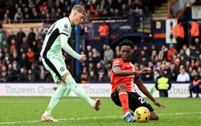 Broja (à direita) tenta sair da marcação dupla da defesa do Luton Town para seguir levando o Chelsea ao ataque Broja (à direita) tenta sair da marcação dupla da defesa do Luton Town para seguir levando o Chelsea ao ataque