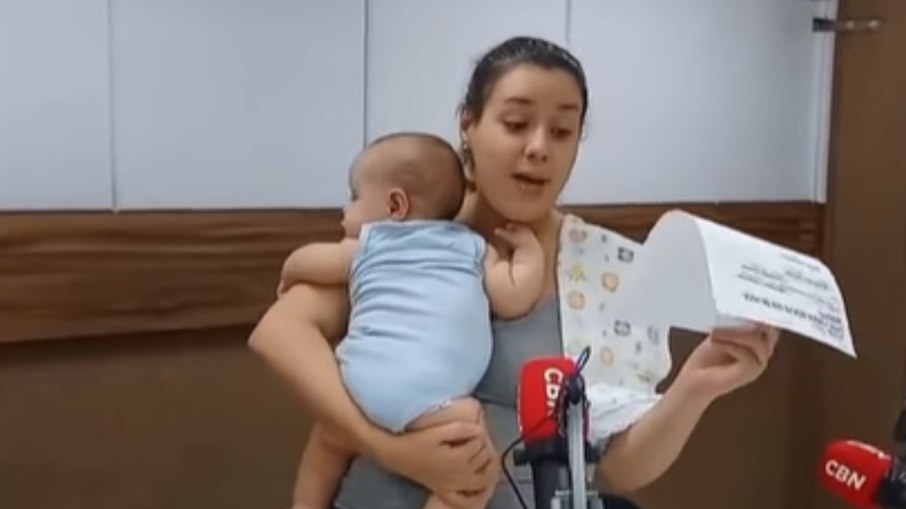 Anne Suênia trabalhando com filho no colo