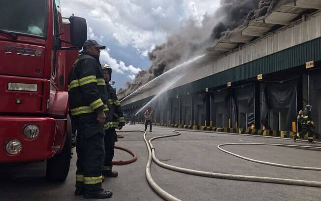 Coluna de fumaça decorrente de incêndio em galpão de supermercado pode ser vista de longe