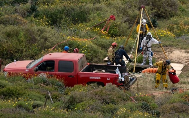 Uma equipe de resgate se prepara para descer em um poço onde foram encontrados corpos perto da praia de La Bocana, delegação de Santo Tomás, em Ensenada, estado de Baixa Califórnia, México, em 3 de maio de 2024