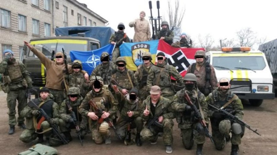O Batalhão de Azov em foto de 2016. As bandeiras ao fundo mostram os símbolos da Otan, o 