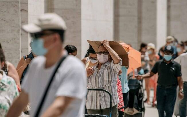 Nova-iorquinos em necessidade esperam em uma longa fila para receber produtos de graça no Lincoln Center