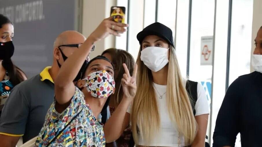 de máscara, Sarah tira foto com os fãs em aeroporto de São Paulo