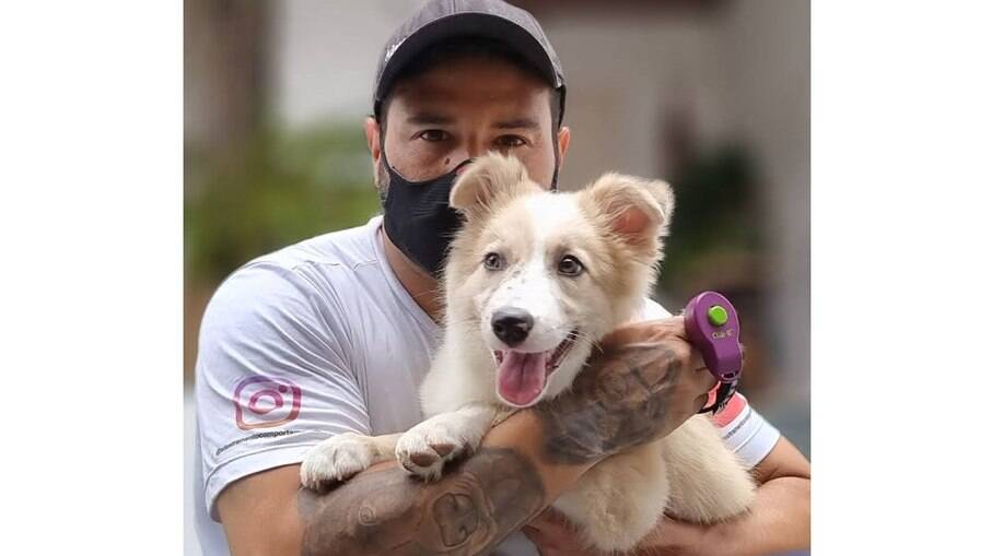 André Almeida com a cachorrinha Nikita. O aparelho que o adestrador segura na mão se chama Clicker