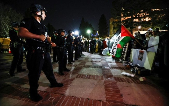Estudantes pró-palestina mantêm suas posições após a polícia invadir seu acampamento no campus da Universidade da Califórnia (UCLA), em Los Angeles, na madrugada de 2 de maio de 2024