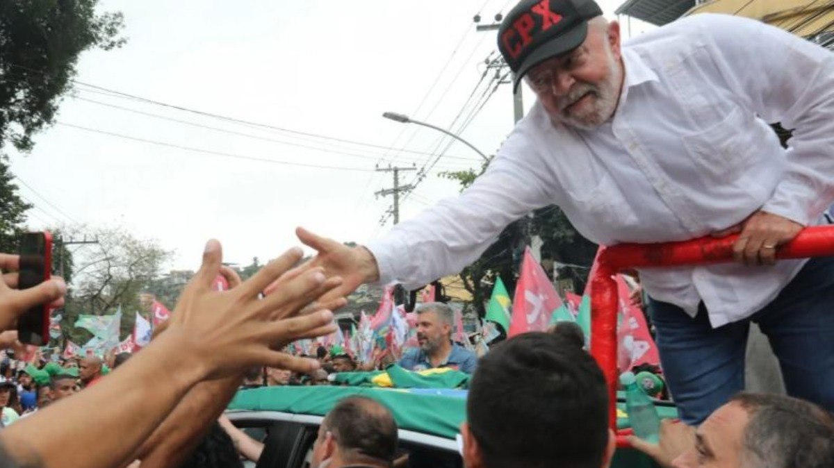 Lula usando o boné com a sigla 'CPX' durante evento de campanha no Complexo do Alemão 