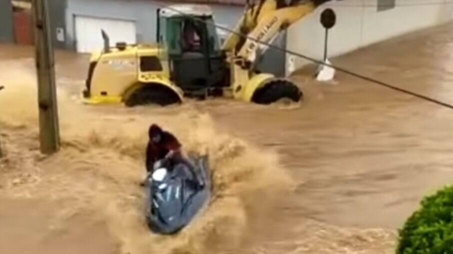 Um homem anda de jetski nas enchentes de Salinas, em Minas Gerais