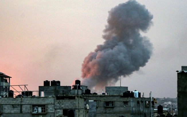 Uma coluna de fumaça acima de edifícios durante um ataque israelense em Rafah, no sul da Faixa de Gaza, em 11 de maio de 2023
