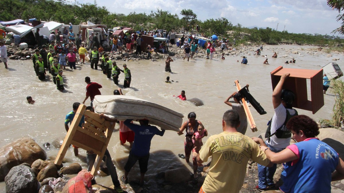 Após repressão do governo da Venezuela, imigrantes carregam seus pertences na fronteira com a Colômbia