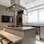 Decoração: como planejar uma cozinha organizada e charmosa Nesta cozinha, o branco e o creme se mesclam para uma composição sofisticada; a ilha recebe um balcão em sua lateral que funciona como mesa. Foto: Henrique Ribeiro/Meet Arquitetura
