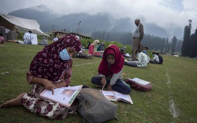 Mundo inteiro discute a retomada das aulas presenciais; acima, escola ao ar livre na Caxemira