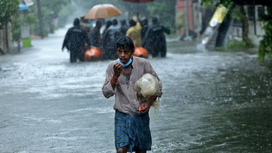 Homem caminha em meio à inundação causada por fortes chuvas em Chennai, na Índia