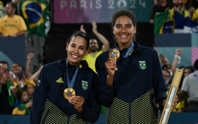 Duda (E) e Ana Patrícia (D) posam com suas medalhas de ouro no pódio após a vitória nos Jogos de Paris-2024, no Estádio da Torre Eiffel, em 9 de agosto de 2024. Duda (E) e Ana Patrícia (D) posam com suas medalhas de ouro no pódio após a vitória nos Jogos de Paris-2024, no Estádio da Torre Eiffel, em 9 de agosto de 2024.