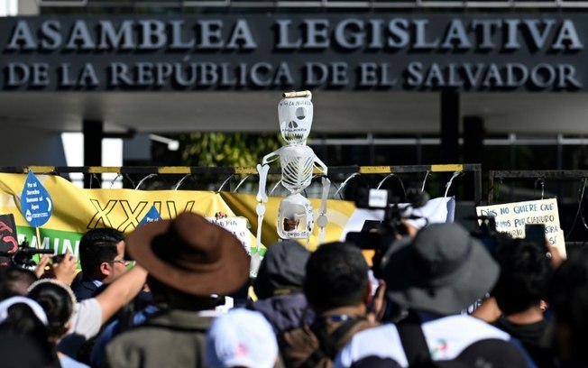 Manifestantes protestam em frente à Assembleia Legislativa contra a derrubada da lei que proíbe a mineração de metais em San Salvador, 23 de dezembro de 2024